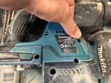 someone is holding a cordless drill in their hand and pointing at the button