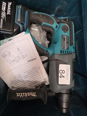 une boîte bleue contenant des outils, notamment une perceuse, un marteau et d'autres objets
