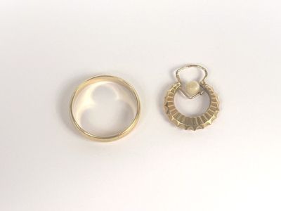 two gold rings and a pearl ring on a white surface