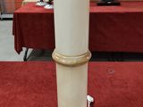 un socle blanc posé sur un tapis rouge dans une pièce
