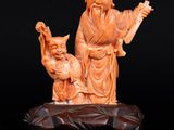 une image représentant une figurine sculptée d'un homme et d'un chat