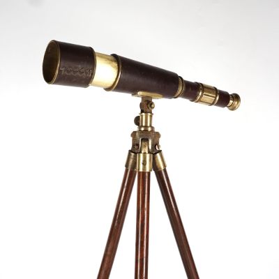 un télescope ancien posé sur un trépied, devant un fond blanc