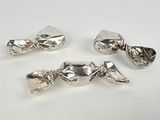 three pieces of silver plated candy sitting on top of a white table