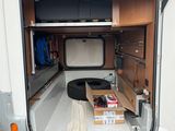a small camper with a bed in the back of it