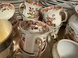 many cups and saucers sitting on a table