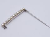 a close up of a needle with a pearl bead on it