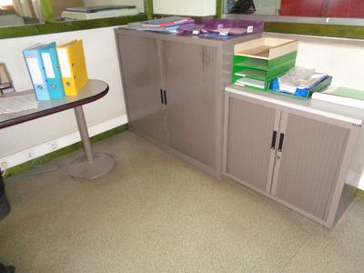 un bureau avec une armoire à dossiers dans un coin de la pièce