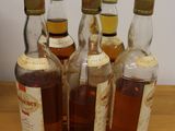 several bottles of alcohol are lined up on a wooden table