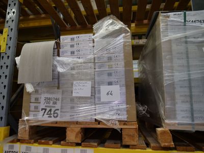 une palette remplie de cartons, placée sur une autre palette dans un entrepôt