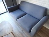a blue couch sitting in a living room next to a coffee table