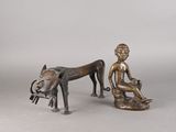des figurines en bronze représentant un garçon et un chien assis sur un banc