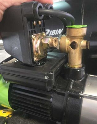 un gros plan d'une pompe à eau tenue par une main