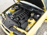a yellow car with its hood open on the street