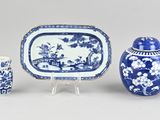 three pieces of blue and white pottery including a vase, a tray, and a vase