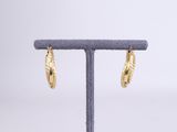 a pair of gold hoop earrings on a stand