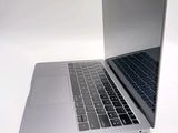a silver laptop with a black keyboard on a white surface