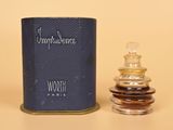 une image représentant un flacon de parfum à côté d'un vaporisateur de parfum