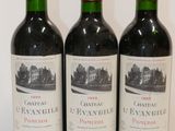 three bottles of red wine are lined up on a white surface