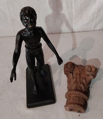 une petite statue représentant un garçon debout à côté d'une statue représentant un homme