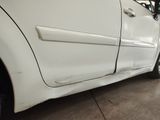 a white car that has been dented and is parked in a garage