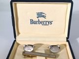 une paire de montres de poignet et une pince à cravate dans un coffret