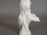 a white statue of a woman with long hair on a table