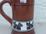 une tasse marron ornée d'un motif en noir et blanc