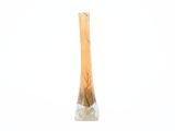 un vase en verre muni d'une poignée en bois, posé sur une surface blanche