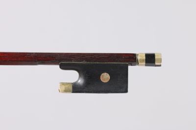 a close up of a violin bow on a white surface