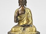 a bronze statue of a buddha sitting on a lotus base