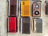 a lot of old radio ' s and other electronics laid out on the floor