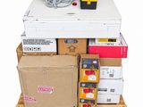 a stack of boxes on a pallet next to a box of wires