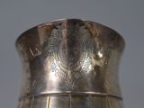 a silver vase sitting on a table with a gray background