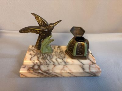 a statue of a bird and a vase on a marble base
