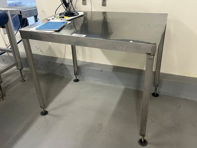 une table sur laquelle se trouve un ordinateur portable, dans une pièce