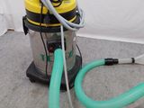 un aspirateur posé sur le sol à côté d'un tuyau