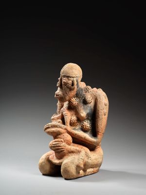 une vieille figurine représentant un homme tenant un bébé dans ses bras