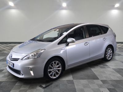 La Toyota Prius argentée est garée sur un sol carrelé à damier.