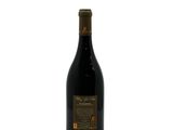 a bottle of red wine sitting on top of a white table