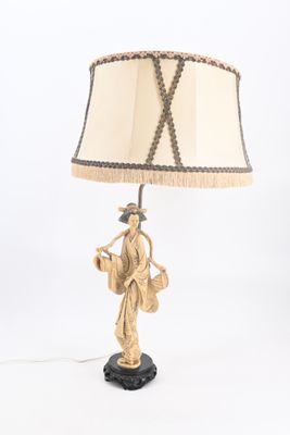 une image représentant une lampe sur laquelle est posée une femme tenant un panier