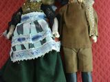 two dolls that are laying on a red blanket