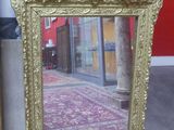 a gold picture frame sitting on the floor next to a red wall