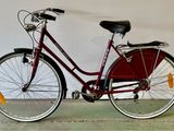 un vélo rouge appuyé contre un mur blanc
