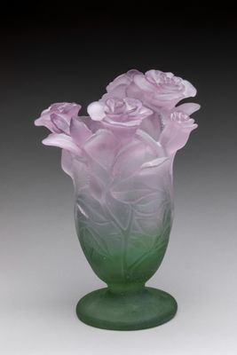purple and green glass vase with flowers in it on a table