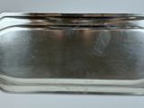 a silver tray with a handle on a table