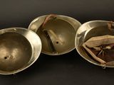 three metal bowls with a spoon and a spoon rest on a black surface
