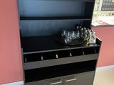 a black cabinet with wine glasses on top of it