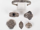 an assortment of silver jewelry including a cuff, ring, and other items