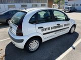 a small white car parked in a parking lot
