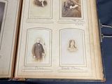 an old book with pictures of people on it sitting on a table